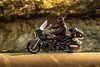 Profile angle of a person riding a motorcycle on a road.