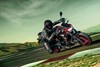 Three-quarter front angle of a person riding a motorcycle on a racetrack.