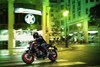Profile angle of a person riding a motorcycle on a city street.