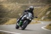 Front angle of a person riding a motorcycle on a winding road.