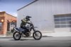 Side angle of a person riding a motorcycle in an urban city.
