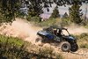 Side angle of a person driving a side x side off-road.